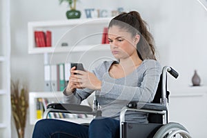 Frustrated woman in wheelchair making phone call