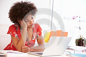 Frustrated Woman Working At Desk In Design Studio