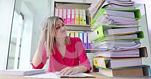 Frustrated at work female employee overloaded with paperwork