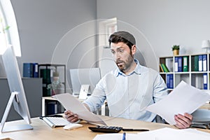 Frustrated and worried businessman looks at bad performance of the company on the documents, an evil man holds in his hands