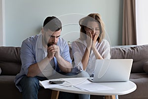 Frustrated worried millennial husband and wife reading bankrupt message