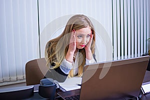 Frustrated worried young woman looks at laptop upset by bad news, teenager feels shocked afraid reading negative bullying message,