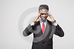 Frustrated young African man holding fingers on head and looking at camera while standing against grey background