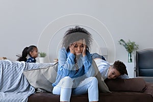 Frustrated young African mom tired of watching hyperactive children