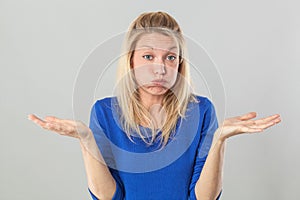 Frustrated young blond woman puffing her cheeks out