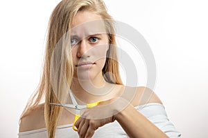 Frustrated young blonde woman having a problems with bad hair on white background
