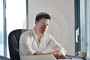 Frustrated young business man working on laptop computer at home