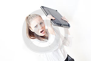 Frustrated young business woman throwing her laptop