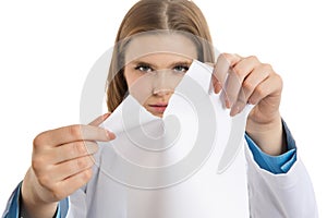 Frustrated young female doctor tearing paper