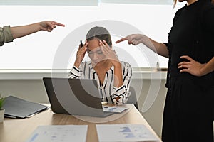 Frustrated young female employee receiving unfair reprimand rebuke, suffers from bad attitude at work. Stress at work