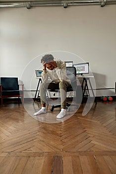 Frustrated young guy, trader holding head in panic after stock market business failure, sitting at desk, trading online