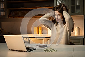 Frustrated Young Woman Budgeting Finances at Kitchen Table