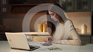 Frustrated Young Woman Budgeting Finances at Kitchen Table