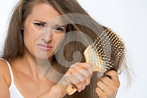 Frustrated young woman combing hair