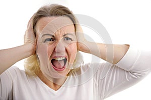 Frustrated young woman holding hands on ears, keeping eyes closed and cry.