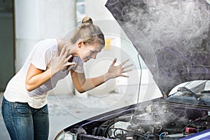 Woman Looking Under The Hood Of Breakdown Car photo