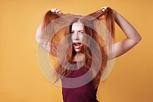 Frustrated young woman pulling and tearing her hair