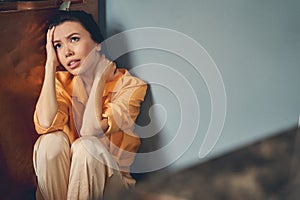Frustrated young woman son the floor at home