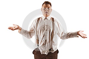 Frustration, resentment. Overweight boy in white shirt and suspenders isolated over white studio background. Concept of