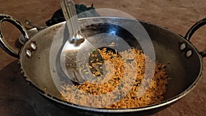 Fry coloured rice at pot with spoon