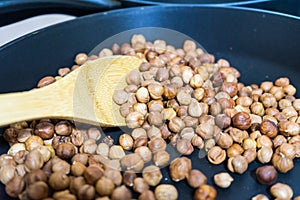 Fry hazelnuts in a frying pan. fresh nuts in the pan.