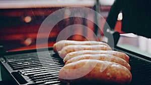 Fry sausage on the grill. Process of preparing BBQ Brats. Taste American Cuisine. Contour highlighting effect