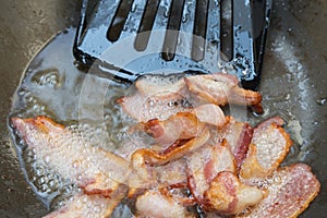 frying bacon in the pan.