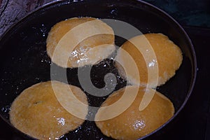 frying chapati(poori) on frying pan, boiling oil in frying pan with dark background, kitchen concept, selective focus