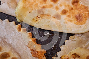 Frying chebureks in oil on a frying pan