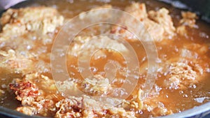 Frying chicken in boiling hot oil