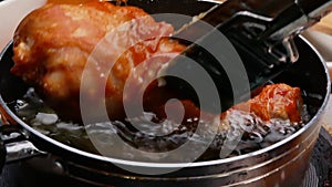 Frying the chicken drumsticks in hot oil in a pan on the kitchen stove. Cooking concept.