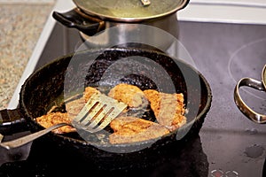 Frying chicken in a pan. Cooking potatoes