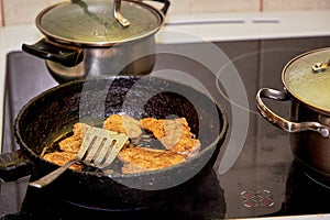 Frying chicken in a pan. Cooking potatoes