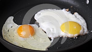 Frying egg in black frying pan.