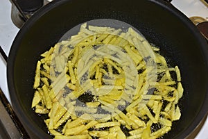 Frying French Fries in sunflower oil in a frying pan