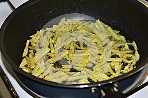 Frying French Fries in sunflower oil in a frying pan