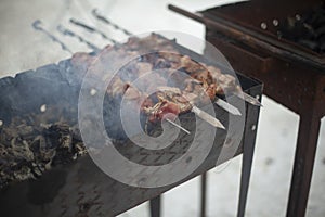 Frying meat on fire. Meat strung on blade. Outdoor kitchen