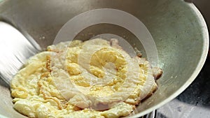 Frying omelet in a pan with hot oil,