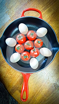 Frying pan with eggs and tomatoes