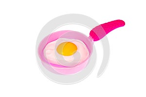 Frying pan with fried eggs. Pink frying pan with scrambled eggs on a white background, isolated image. Toy frying pan