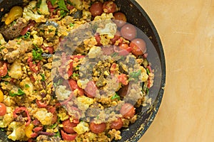 frying pan full of red lentils coocked with vegetables - red tomotoes, mangold , parsley, cauliflower, egg-plant, standing on a