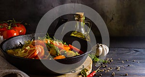 Frying pan with healthy vegetables and a bottle of oil on a rustic wooden table