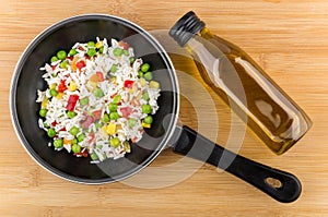 Frying pan with vegetable mix and bottle of vegetable oil