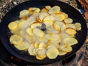 Frying potatoes in oil on a improvised pan