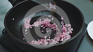 Frying red onions in a pan with olive oil