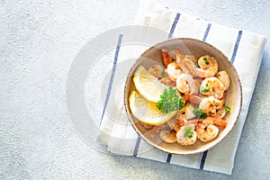 Frying shrimps with lemon in the bawl.