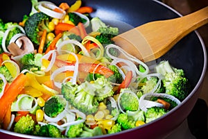Frying vegetables in pan with spatula