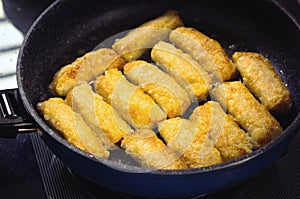 Frying Vietnamese spring rolls in black pan