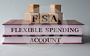 FSA - acronym on wooden cubes on the background of recumbent books