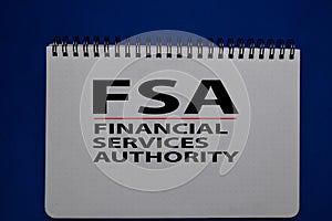 FSA - Financial Services Authority acronym write on a book isolated on Office Desk